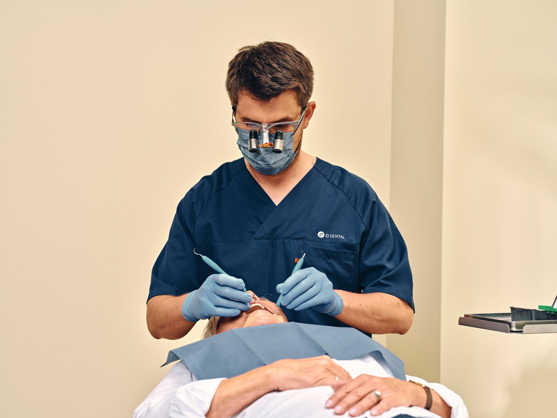 Specialtandlæge Christian Damsgaard udfører tandbehandling hos en patient på klinikken i Bredgade.